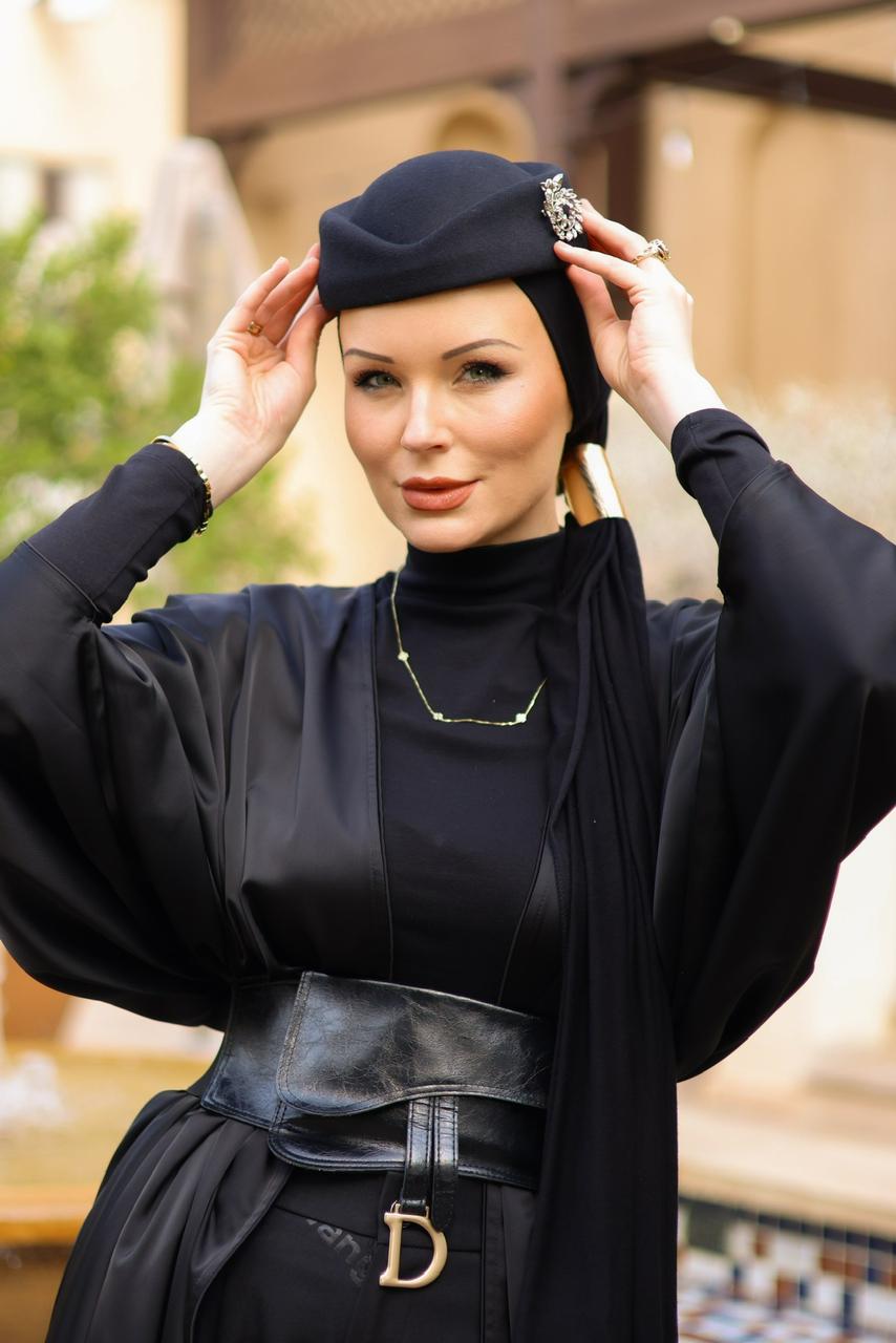 Portrait of Anastasiya Kouzan in black against a warm golden background