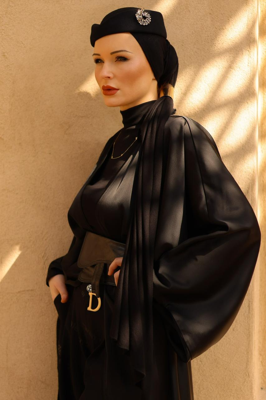 Portrait of Anastasiya Kouzan in black against a warm golden background